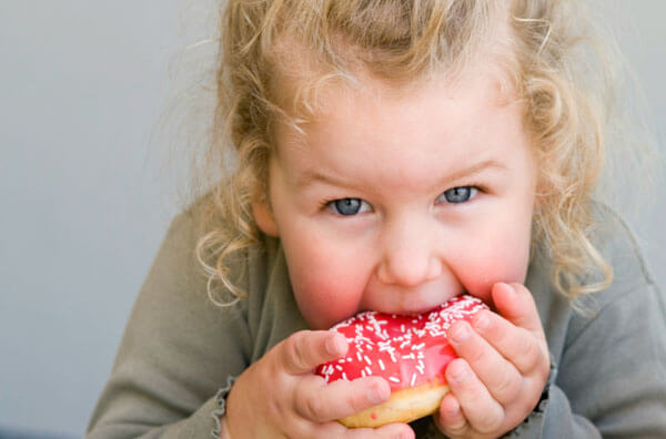 Дитина їсть пончик