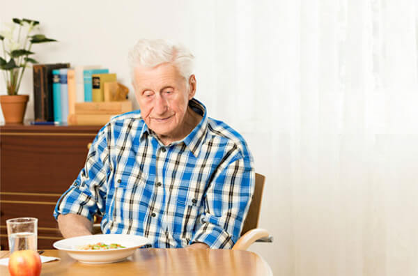 Чоловік похилого віку обідає