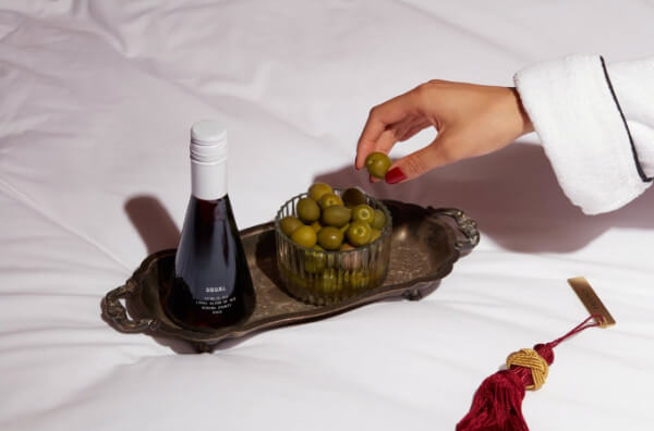 Маленька пляшка вина і оливки