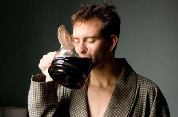 Чоловік п'є каву з кавника