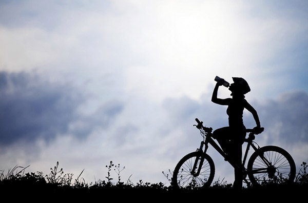 Велосипедистка п'є воду