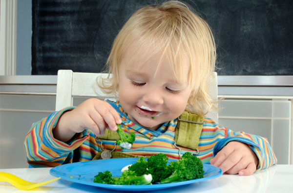Дитина їсть брокколі