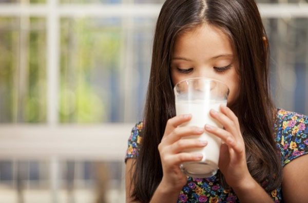 Дівчинка п'є молоко