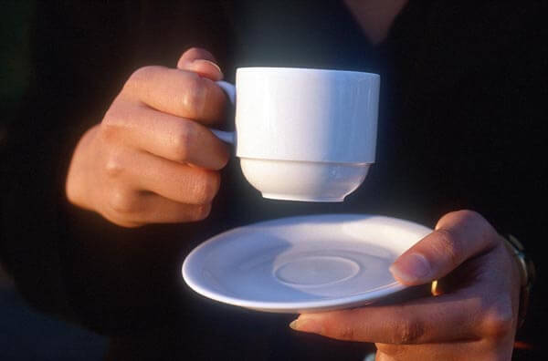 Тримання чашки з кавою за ручку