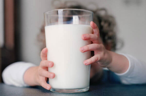 Дитина зі склянкою молока