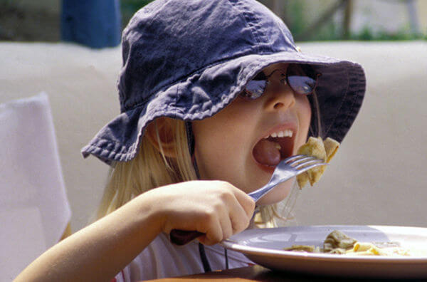 Дівчинка їсть млинець