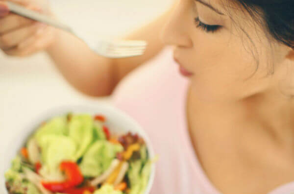 Жінка їсть салат