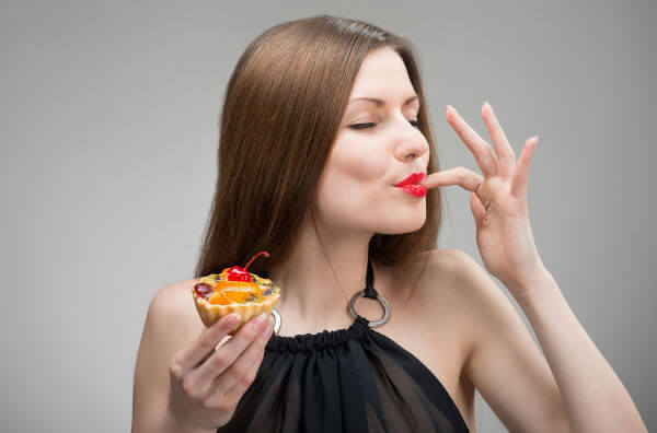 Жінка насолоджується тістечком