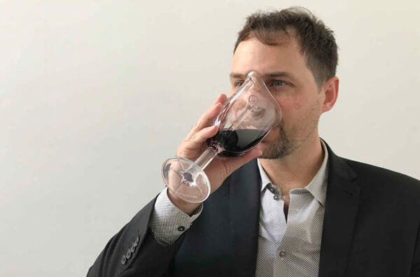 Чоловік п'є вино з келиха-маски
