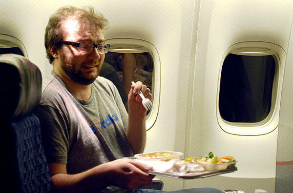 Чоловік їсть у літаку