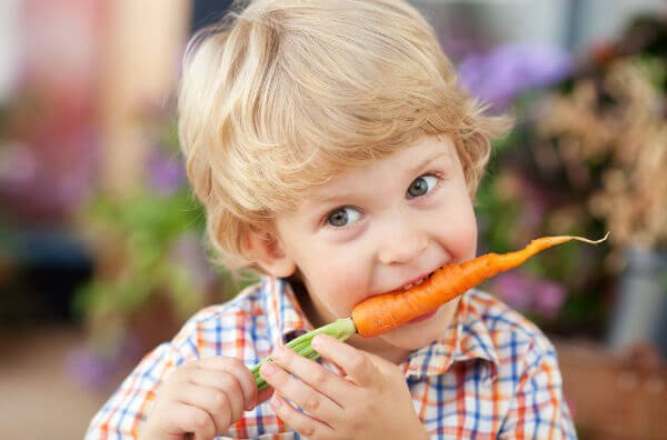 Хлопчик їсть моркву