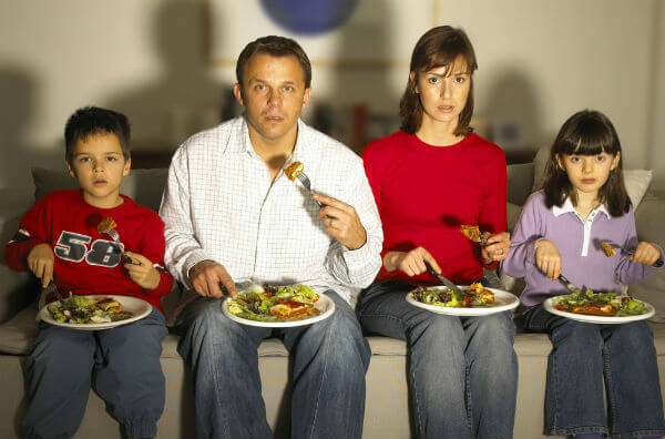Родина вечеряє перед телевізором