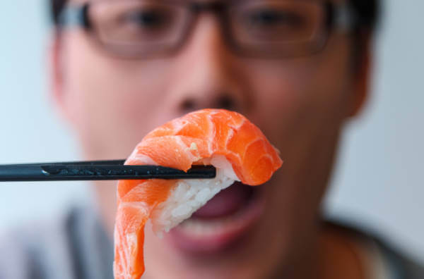 Чоловік їсть суші