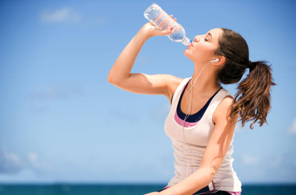 Дівчина п'є воду під час тренування