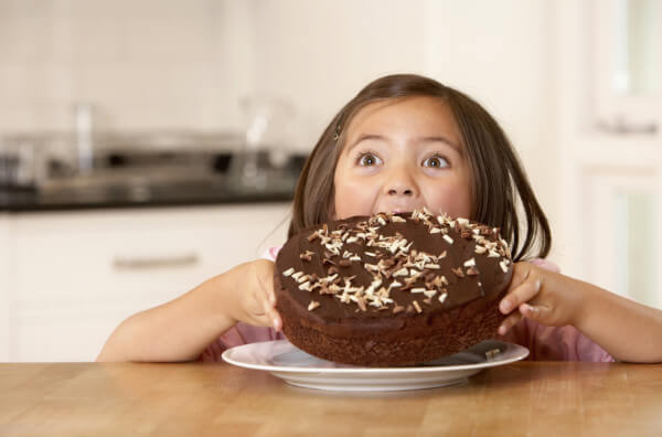 Дівчинка їсть цілий торт