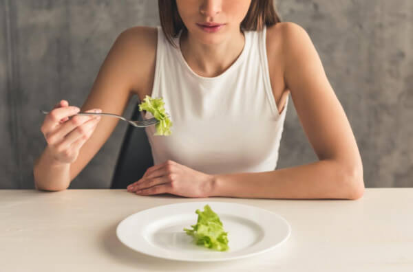 Жінка їсть листя салату