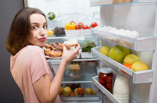 Жінка перед холодильником