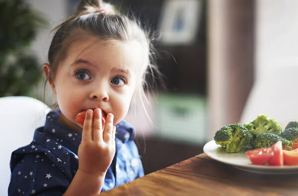 Дитина їсть овочі