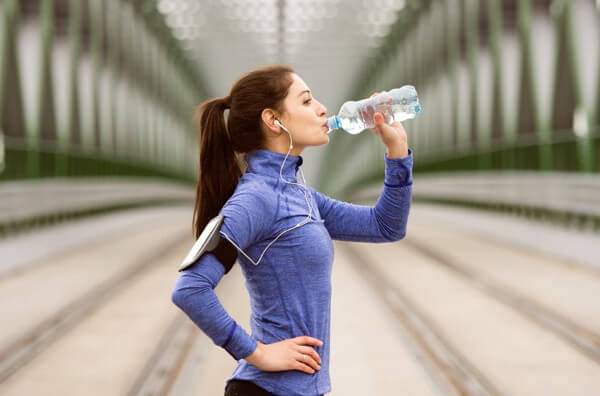 Спортсменка п'є воду