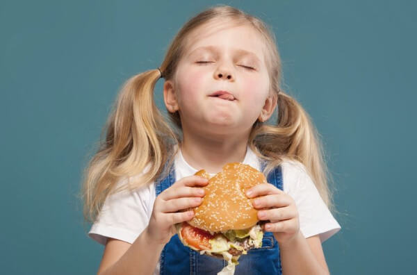 Дівчинка їсть бургер