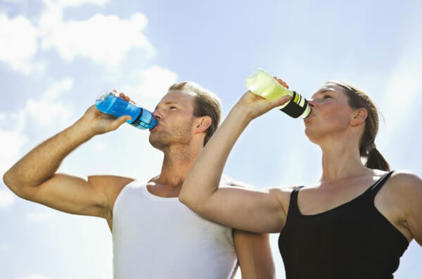 Чоловік та жінка п'ють спортивні напої