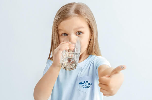 Дівчинка п'є воду