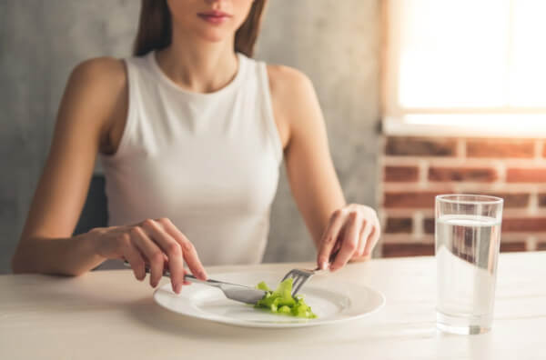 Жінка їсть лист салату