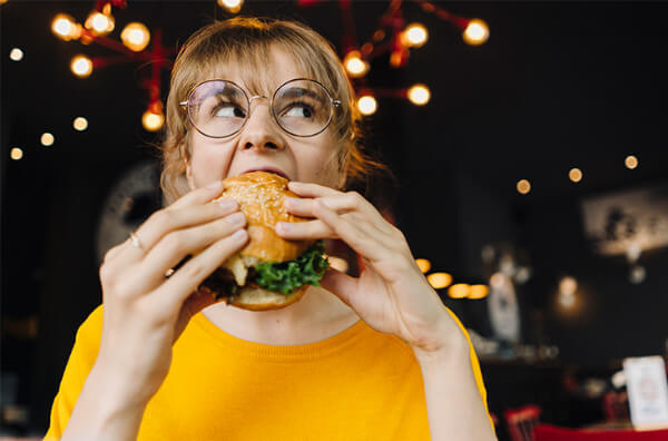 Жінка їсть бургер