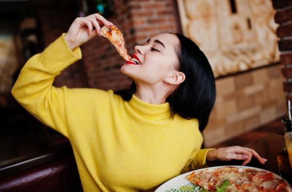 Жінка їсть піцу