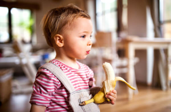 Дитина їсть банан