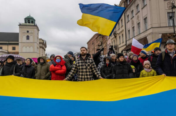 Люди на мітингу з українським прапором