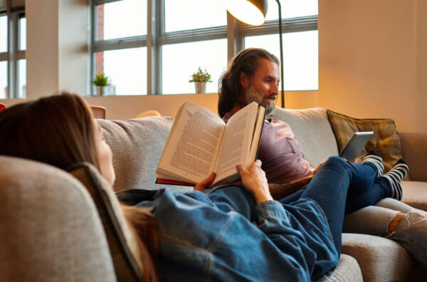 Пара читає книги лежачи на дивані