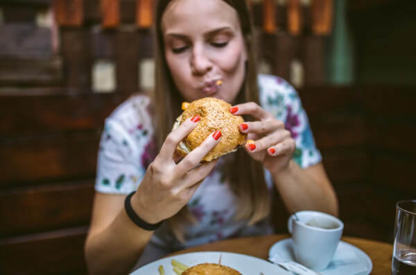 Жінка їсть бургер