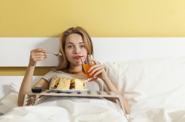 Жінка їсть у ліжку