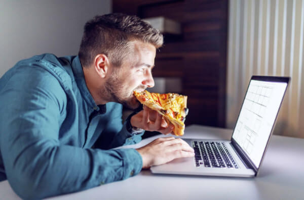 Чоловік їсть піцу