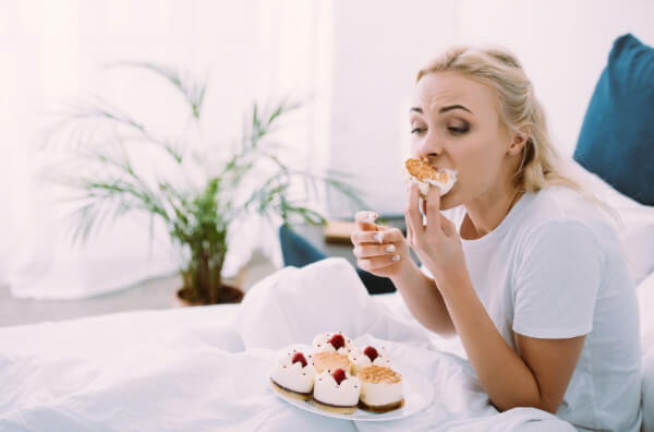 Жінка їсть тістечка