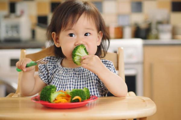 Дитина їсть броколі