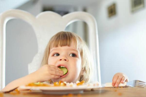 Дитина їсть огірок