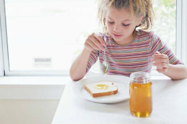 Дитина їсть мед