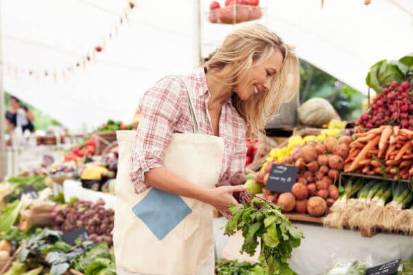 Жінка купує овочі