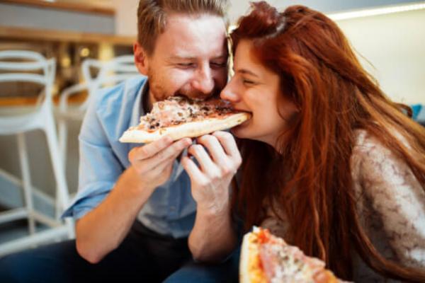Пара їсть піцу