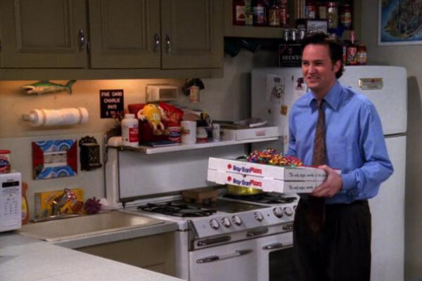 Сцена з серіалу "Друзі", де Чендлер тримає коробки з піцою